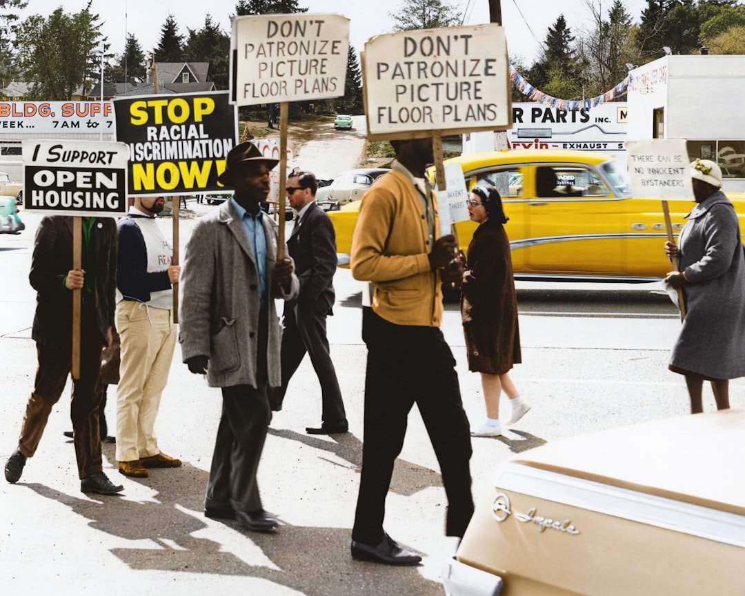 Contact Caption reads, CORE-sponsored demonstration at realtor office of Picture Floor Plans, Inc. Original black and white negative by the Seattle Police Department. Taken May 4th, 1964, Seattle, Washington State, United States (Seattle Municipal Archives). Colorized by Jordan J. Lloyd. Seattle Municipal Archives Series 5210-01: Records of the Office of the Mayor, 1956-1970 http://archives.seattle.gov/digital-collections/index.php/Detail/objects/102614